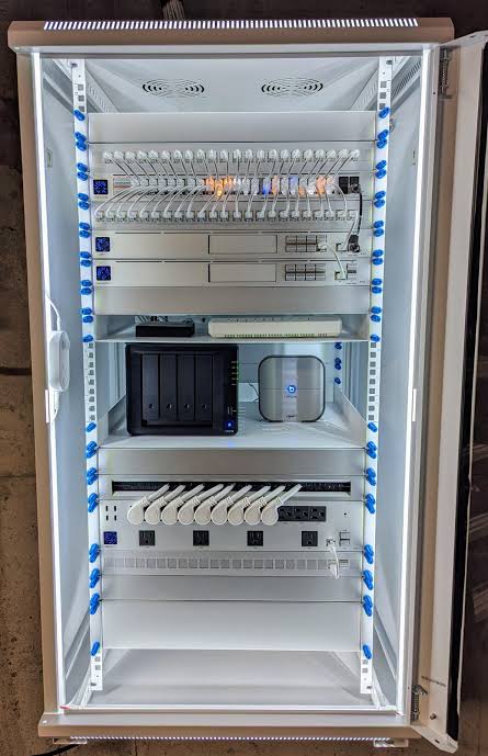 A tidy, fully labelled home comms rack with patch panel, switches, storage and power management