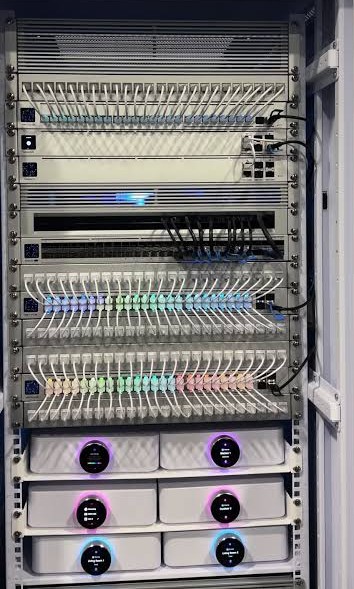 A structured comms rack with colour-coded patch cables and ordered switches